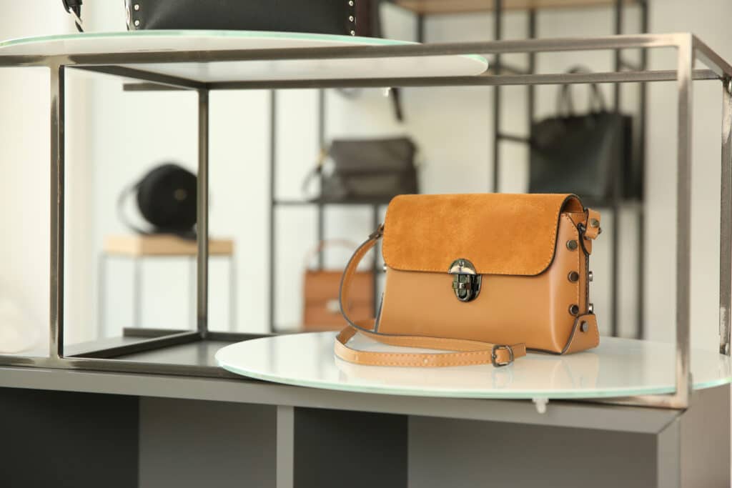 Stylish woman's bag on stand in boutique